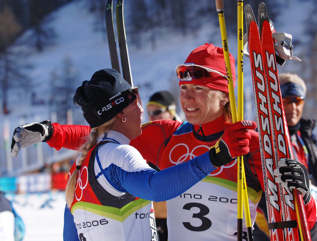 Kateřina Neumannová se v cíli olympijského závodu v Turíně objímá Kristinu Šmigunovou-Vähiovou