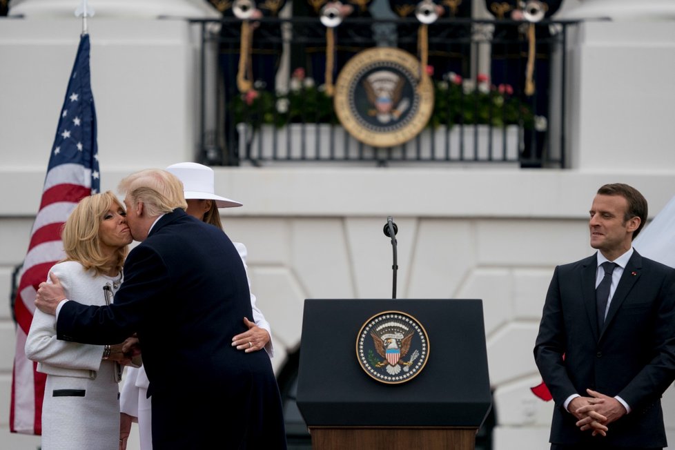 Donald Trump líbá ženu Emmanuela Macrona Brigitte.