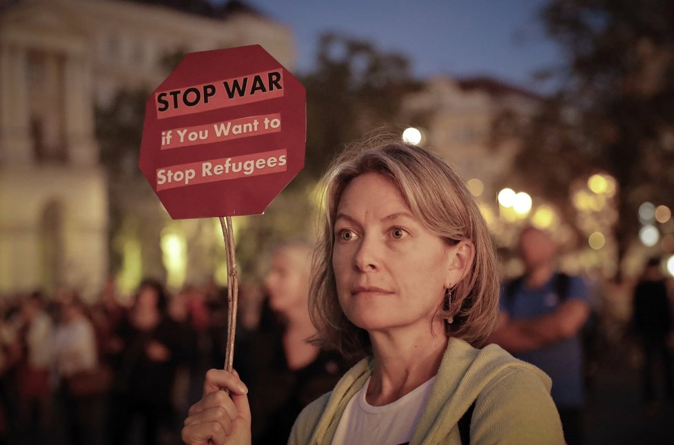 Žena demonstrující proti Viktoru Orbánovi drží transparent s nápisem: „Zastavte válku, jestli chcete zastavit uprchlíky.“