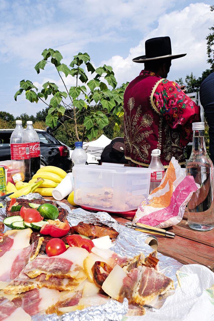 Poutníci si rozkládají sváteční hostinu na stolech i na kapotách aut. Mnozí nám nabízejí jídlo i pálenku. Poutníci si rozkládají sváteční hostinu na stolech i na kapotách aut. Mnozí nám nabízejí jídlo i pálenku.