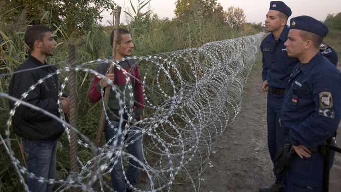 Maďarští policisté se přes hraniční plot baví s běženci na srbské straně hranice