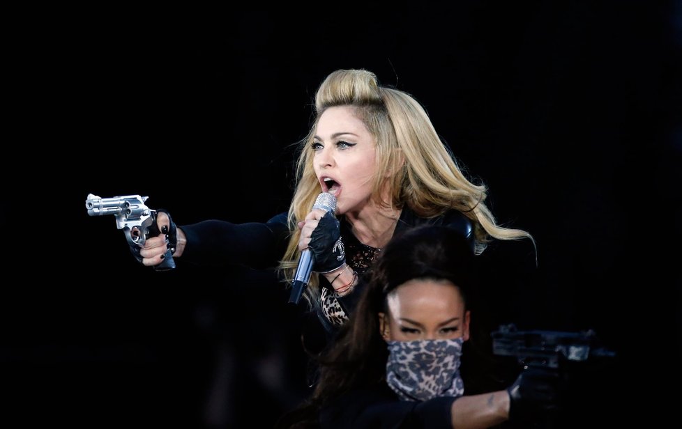 Madonna při show míří maketou do publika.