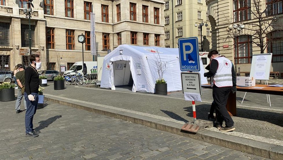 Před pražským magistrátem na Mariánském náměstí vznikly dva stany Českého červeného kříže. Probíhají zde nábory dobrovolníků, kteří v Praze pomáhají například seniorům nebo lidem v karanténě s dodávkami jídla či léků.