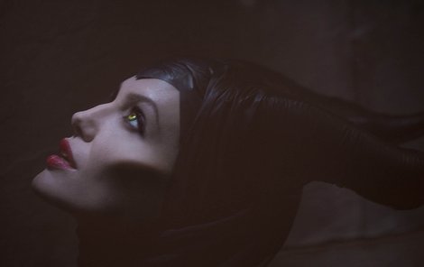 Maleficent v podání Angeliny Jolie – se žlutými čočkami, lícními implantáty a rohy.