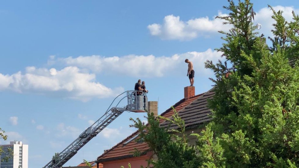 Záchrana muže, který několik hodin odmítal slézt ze střechy domu v Malešicích.