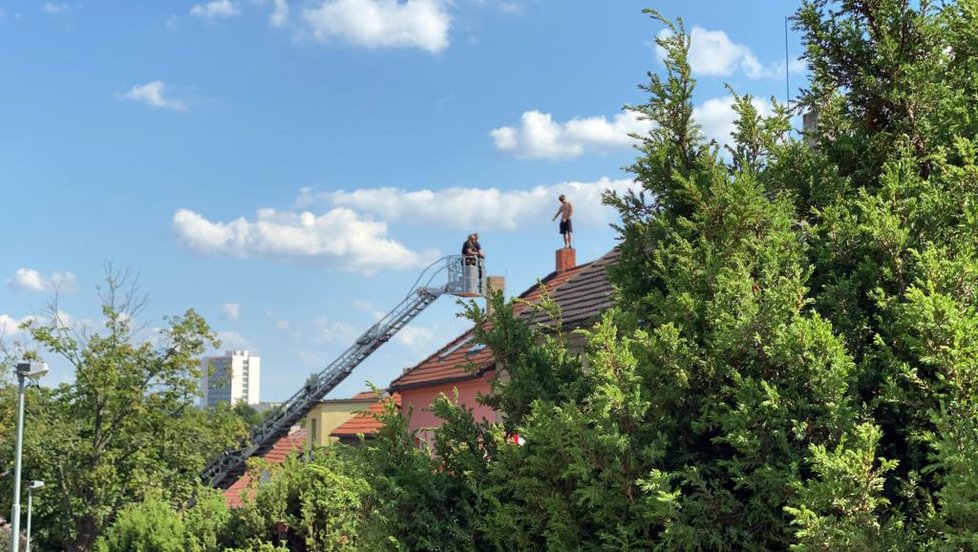 Záchrana muže, který několik hodin odmítal slézt ze střechy domu v Malešicích.