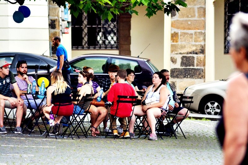 Malostranské náměstí je oázou klidu. Auta už jsou konečně pryč, těší se lidé vysedávající pod stromy.