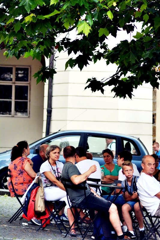 Malostranské náměstí je oázou klidu. Auta už jsou konečně pryč, těší se lidé vysedávající pod stromy.