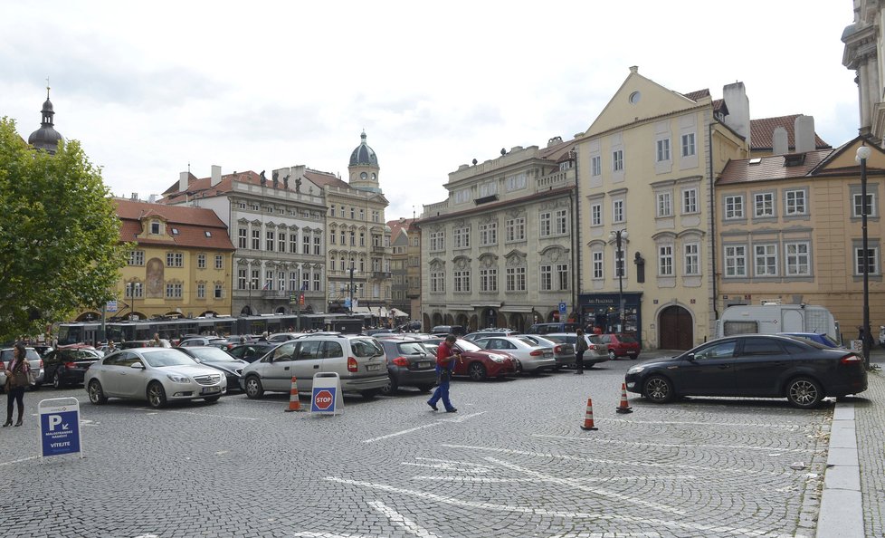 Dolní část Malostranského náměstí s parkovištěm a zastávkami tramvají