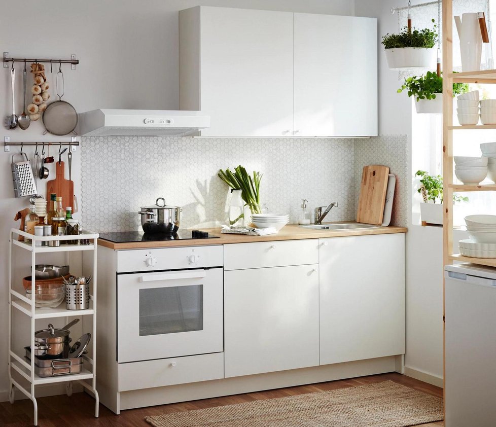 Bílá linka prostor kuchyně prosvětlí a pocitově neubere centimetry. Pro lepší efekt ji doplňte bílým obkladem i bílými spotřebiči. Hřejivost dodají detaily ze světlého dřeva.