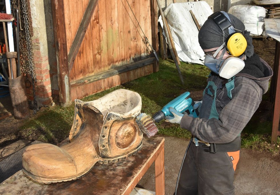 Tomáš (10) nejdříve pilou vyřezal sochu boty a teď jí dolaďuje bruskou detaily.