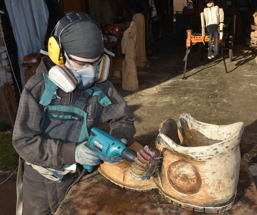 Tomáš (10) nejdříve pilou vyřezal sochu boty a teď jí dolaďuje bruskou detaily.