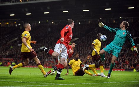 Rooney z Manchesteru United (v červeném) takhle procedil míč mezi beky Arsenalu a gólmanem Almuniou a pečetil na 2:0.