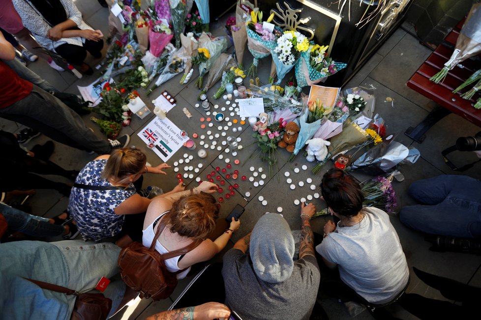 Lidé nosí květiny, svíčky a vzkazy pro oběti teroristického útoku.