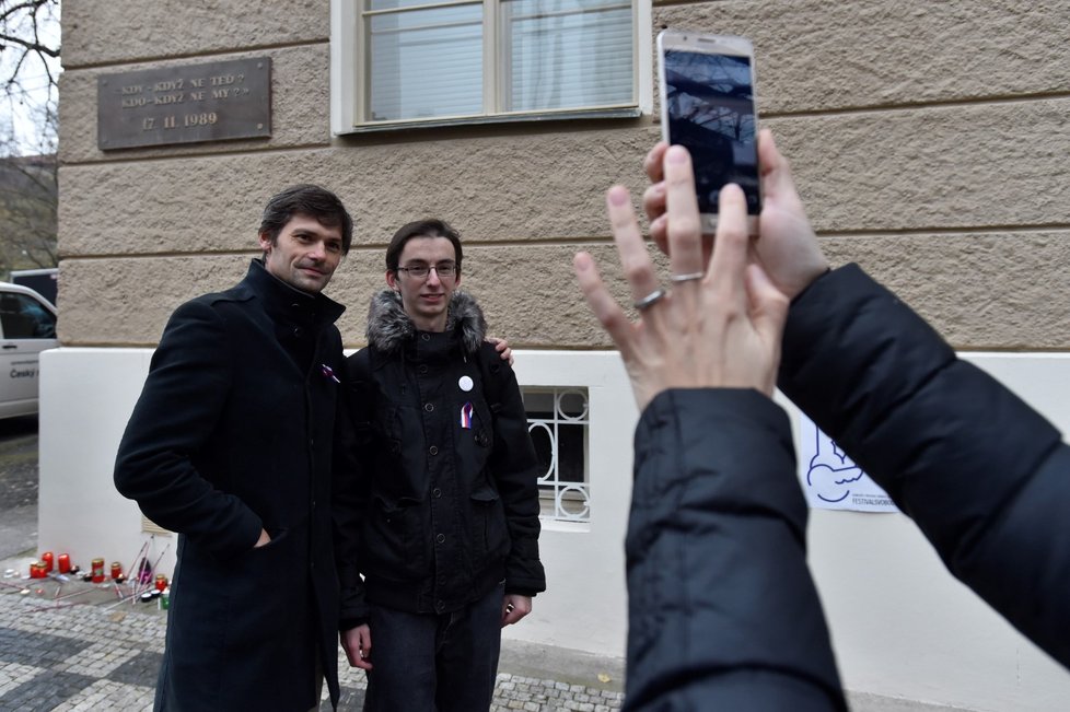 Lékař a prezidentský kandidát Marek Hilšer (vlevo) pózuje pro mobilní fotografii na pražském Albertově, kde spolu s dalšími lidmi uctil 17. listopadu státní svátek u památníku, který připomíná, že právě odtud vyšel 17. listopadu 1989 pochod studentů na Národní třídu.