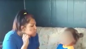 Mladá žena vydechuje kouř dítěti do obličeje.