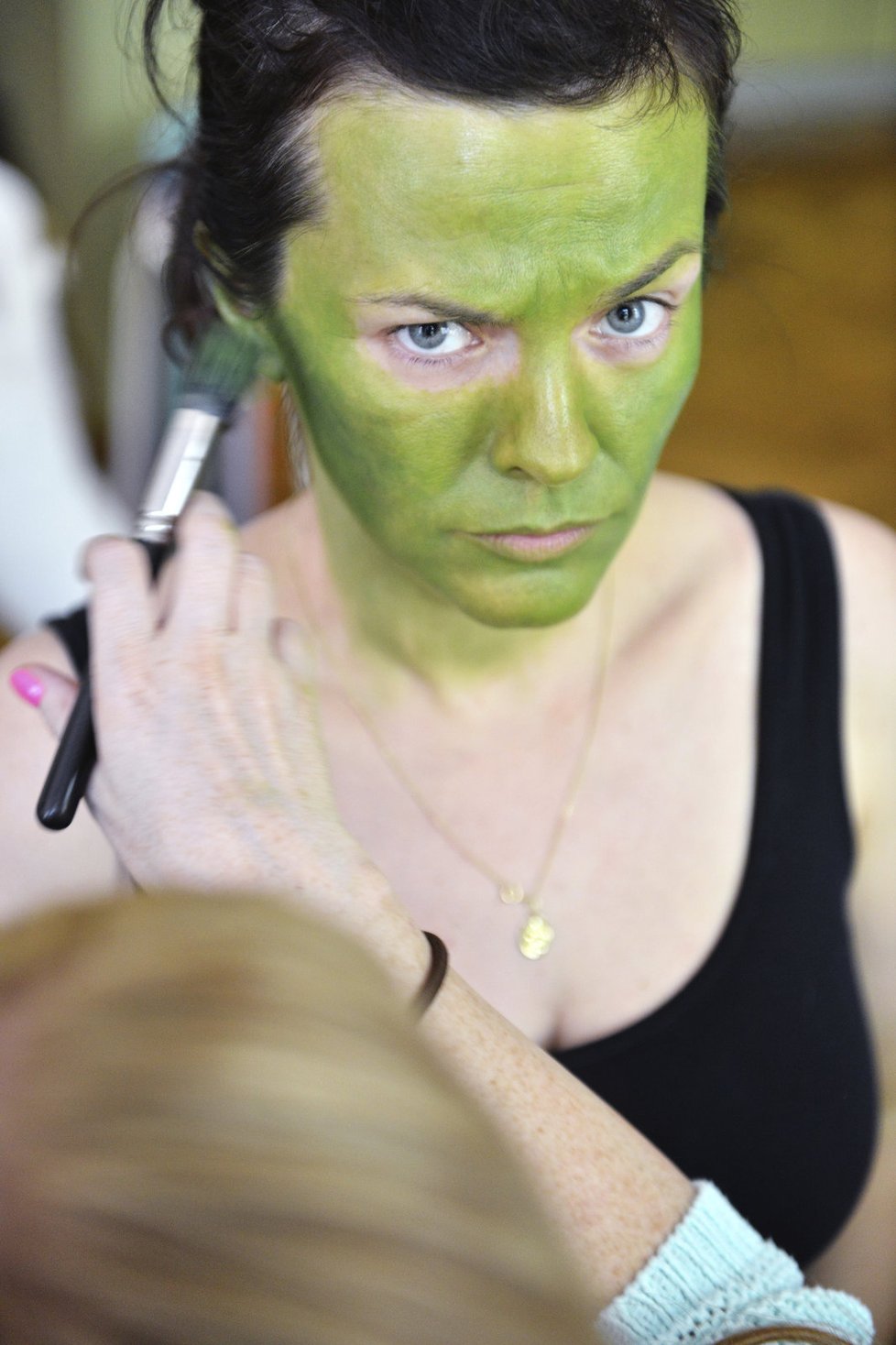 Jako první přišla na řadu zelené divadelní barva, kterou vizážistka pomalovala Martě celý obličej a krk.