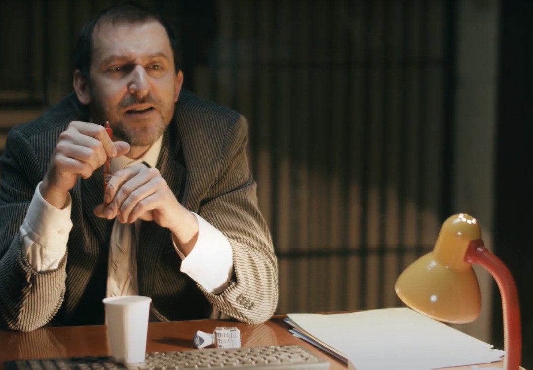 Martin Hofmann ve videoklipu Úředník jako kravaťák.