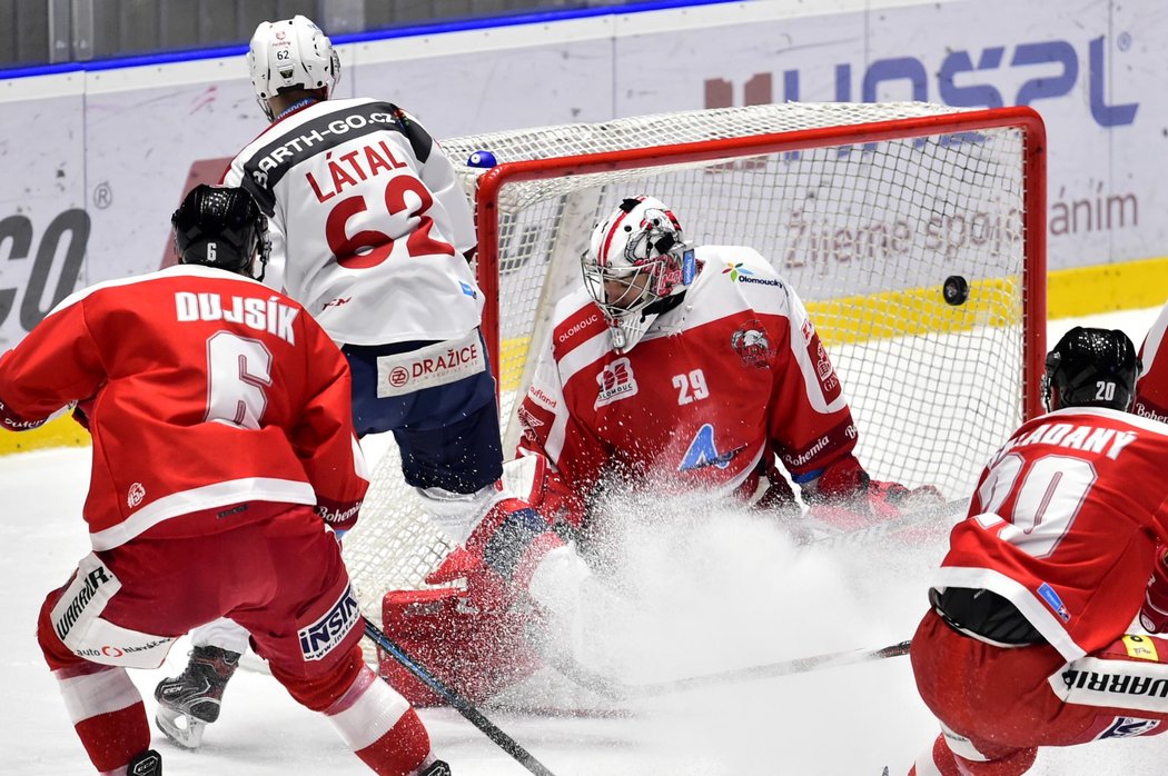 Martin Látal (uprostřed v bílém) překonává brankáře Olomouce Jana Lukáše