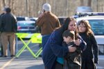Brečící chlapec před základní školou v Newtownu v americkém státu Connecticut, kde došlo k hrůznému masakru
