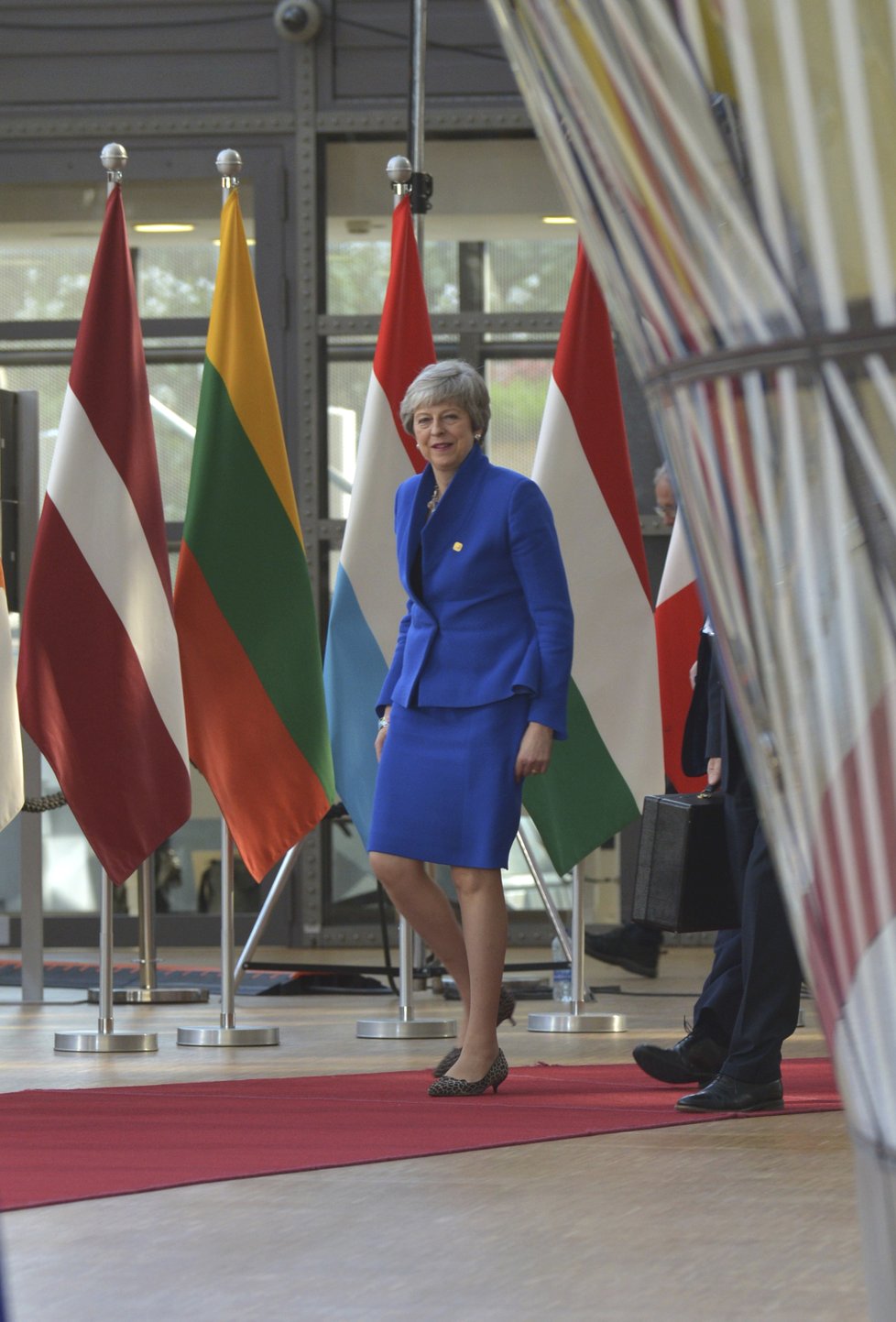 Britská premiérka Theresa Mayová přijela do Bruselu i tentokrát s hlavou vzhůru a úsměvem na rtech. Oblékla se do modré - tedy barvy, která převládá na vlajce EU. Stejnou barvu zvolila i německá kancléřka Angela Merkelová.