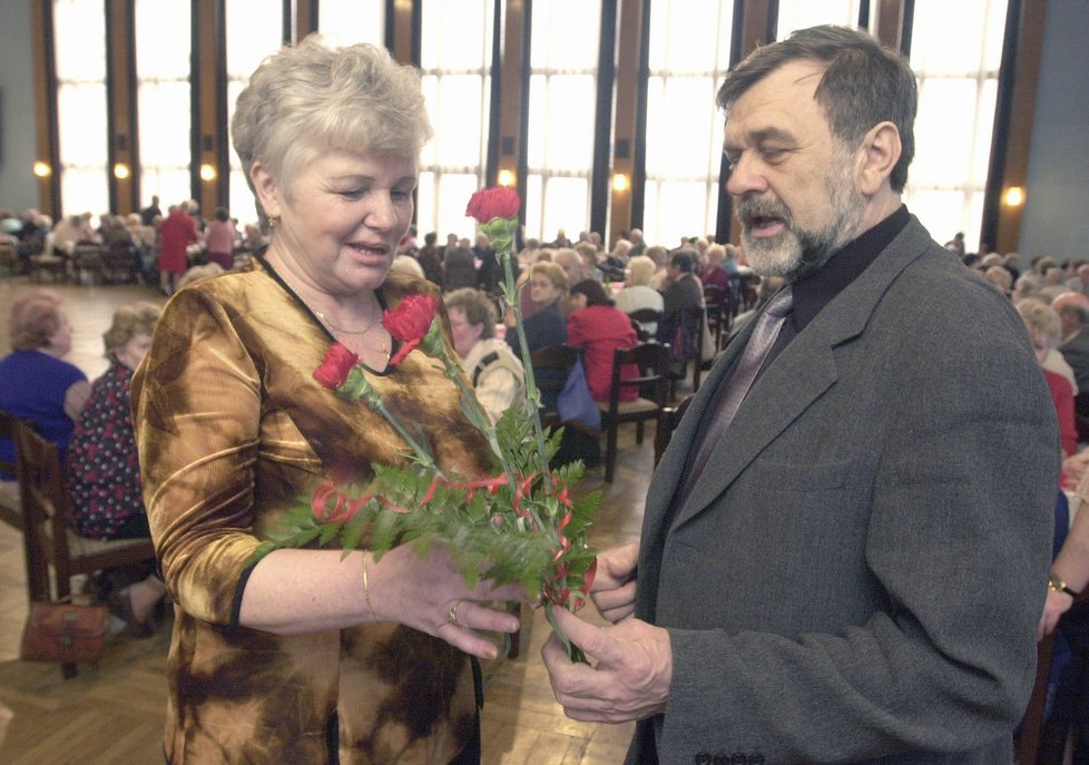 Komunistický senátor Jaroslav Doubrava předává typický dárek – karafiáty.