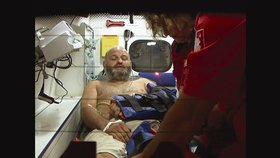 Pavel Jelínek v sanitce. Lékaři ošetřují jeho poranění, která mu způsobil medvěd