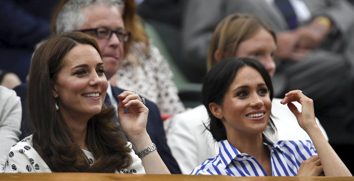 Meghan a Kate se na tenisovém zápase.