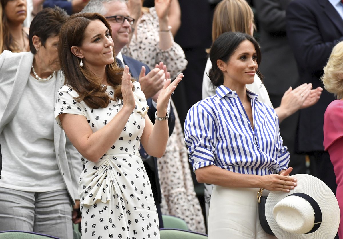 Meghan a Kate se na tenisovém zápase.