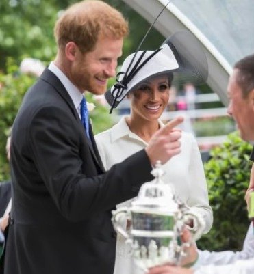 Princ Harry vtipně hrozil žokejovi, který políbil ruku vévodkyni Meghan.