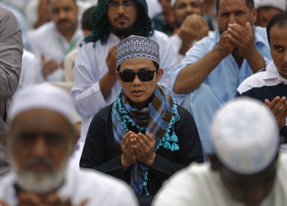 Muslimští poutníci se modlí před Velkou mešitou v Mekce, než vyrazí na pouť