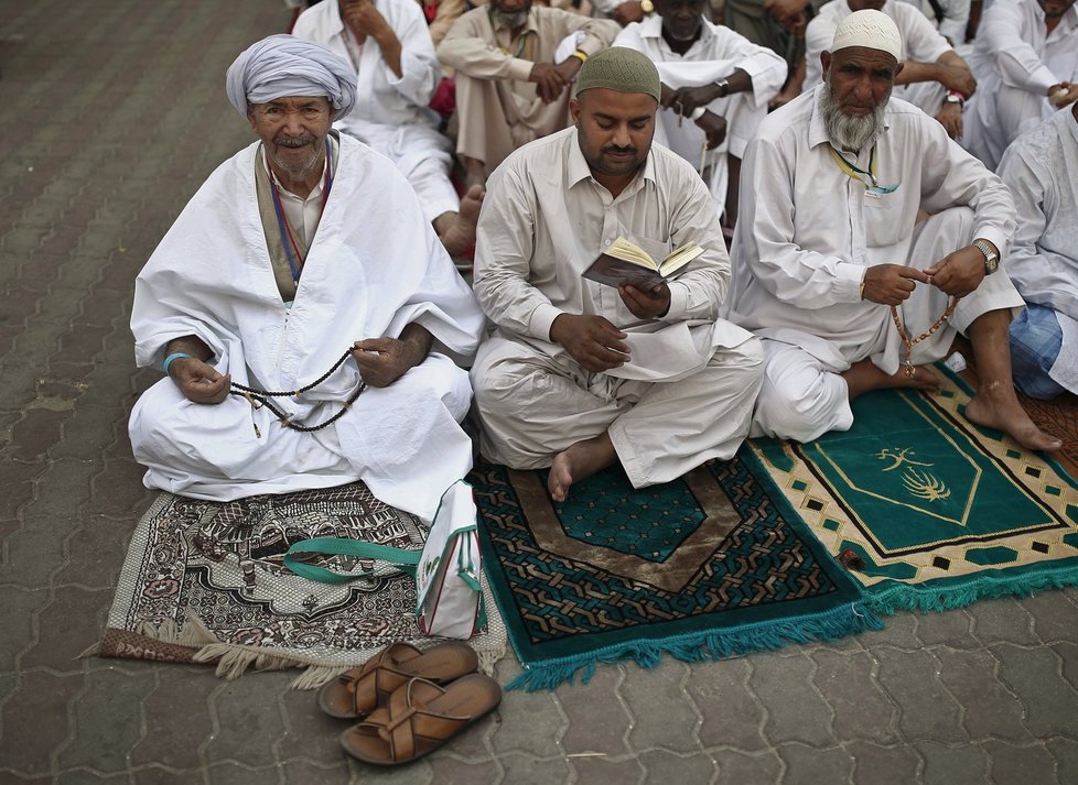 Muslimští poutníci se modlí před Velkou mešitou v Mekce než vyrazí na pouť