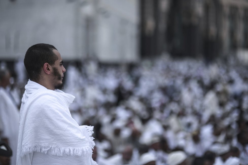 Muslimští poutníci se modlí před Velkou mešitou v Mekce, než vyrazí na pouť