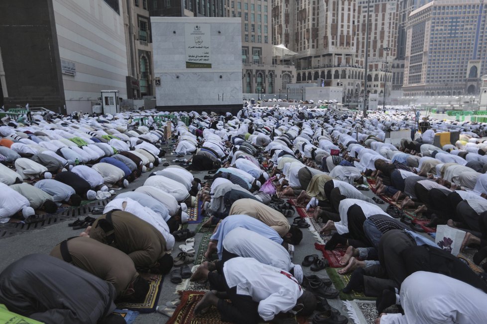 Muslimští poutníci se modlí před Velkou mešitou v Mekce, než vyrazí na pouť