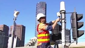 Dělník instaluje v australském Melbourne nový semafor s ženským panáčkem.