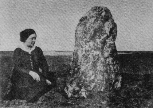 Nejstarší fotografie menhiru Kamenný slouha z roku 1914. Na snímku klečí Božena Štorchová, manželka známého spisovatele.