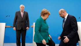 Merkelová a Schulz, v pozadí Seehofer