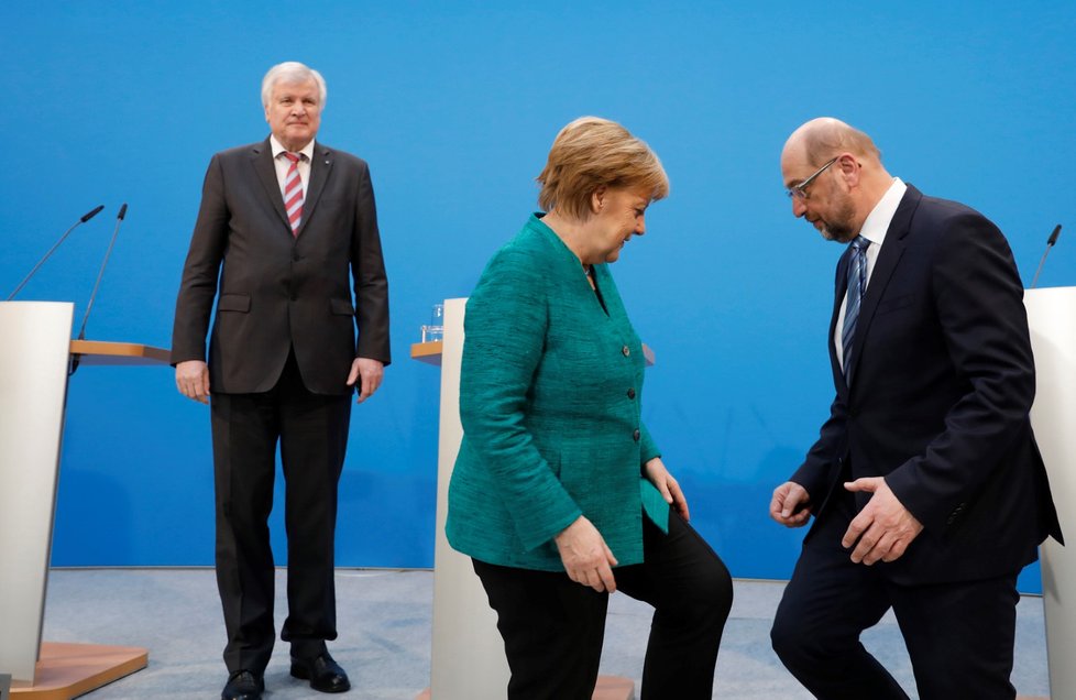 Merkelová a Schulz, v pozadí Seehofer