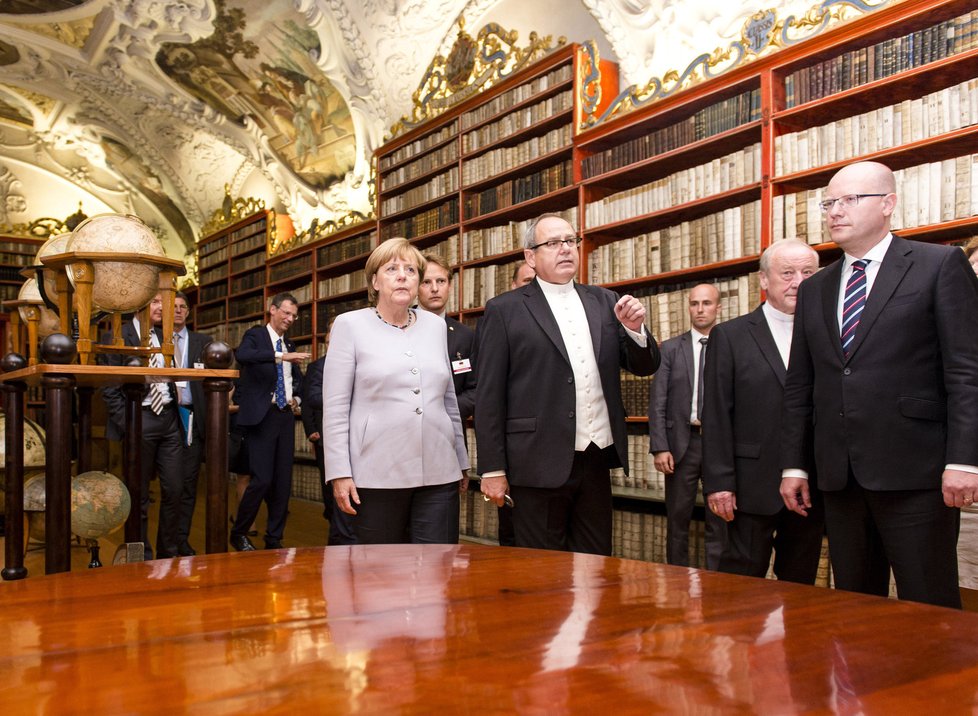 Německá kancléřka Angela Merkelová si v doprovodu premiéra Bohuslava Sobotky (zcela vpravo) a ředitele knihovny Strahovského kláštera Gejzy Šidlovského (po její levici) prohlédla 25. srpna knihovnu Strahovského kláštera v Praze.