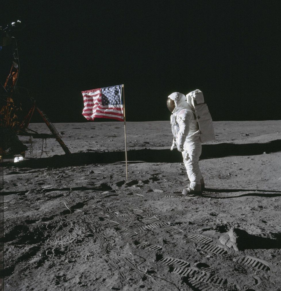 Astronaut Edwin „Buzz“ Aldrin pózuje u vlajky Spojených států, kterou s Neilem Armstrongem vztyčili na Měsíci. Při odletu však tlak motorů vlajku porazil.