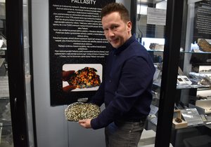 Světlo prosvítá nejkrásnějším typem meteoritů muzea. Řez pallasitu z Keni ukazuje Jaroslav Filip (40).