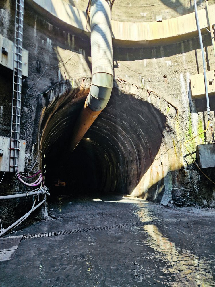 Vstup do tunelu ze šachty a s mohutnou rourou odsávací vzduchotechniky