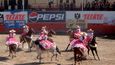 Escaramuzas neboli cowgirls mají družstva dvě – jedno v růžovém a druhé v blankytně modrém oděvu. Na koních sedí po dámském způsobu a drezuru zvládají bravurně.
