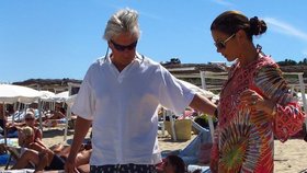 Michael pomáhá Catherine z pláže vystoupat na mole, odkud je vzal člun na jachtu