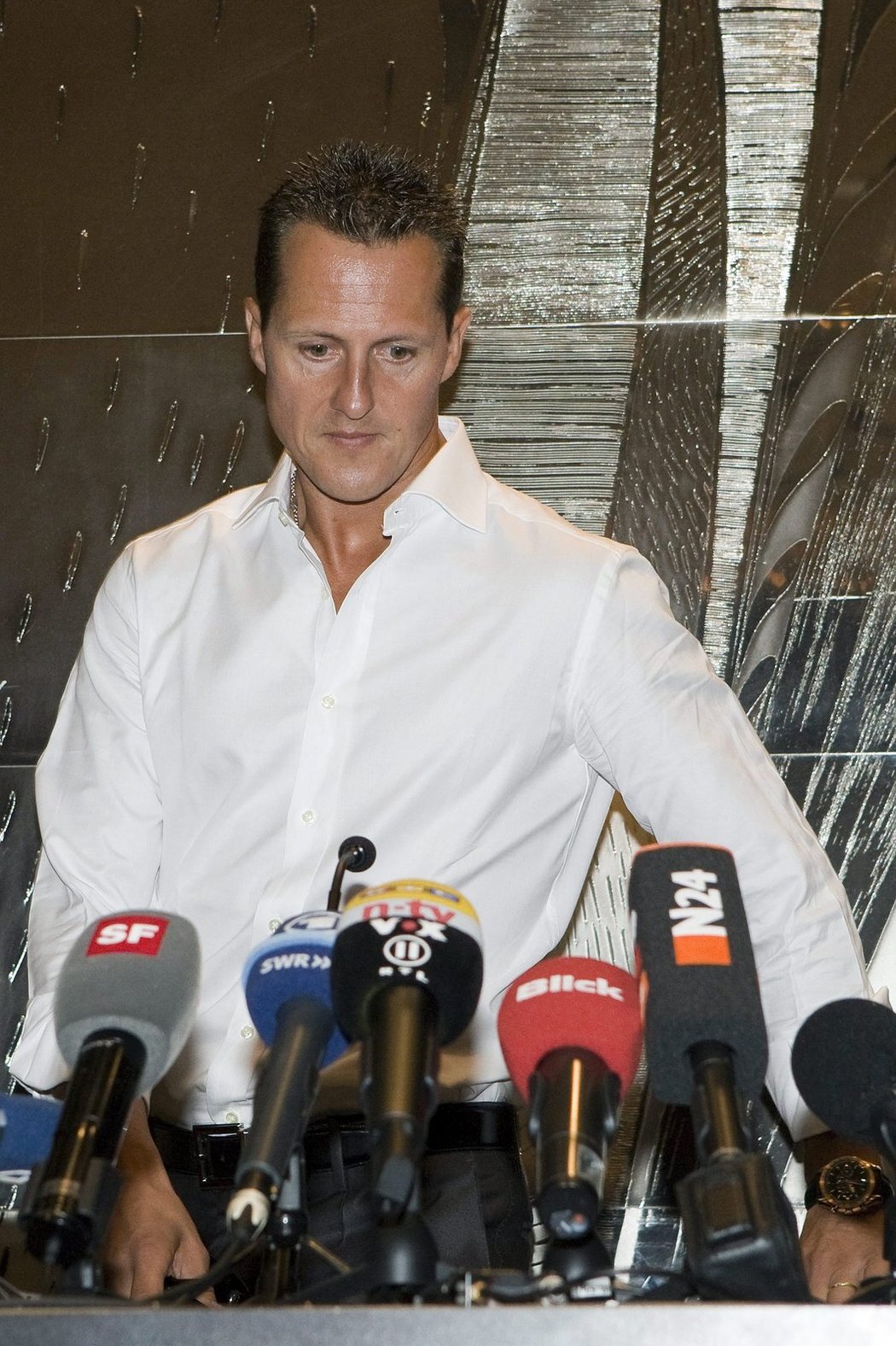Michael Schumacher při tiskové konferenci. Teď leží v nemocnici s ošklivým zraněním.