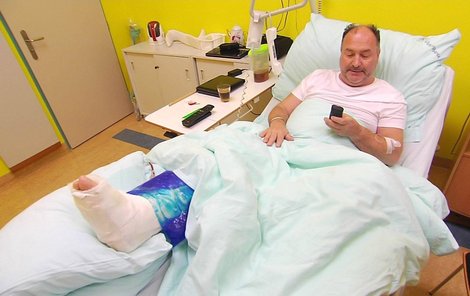 Michal David na nemocničním lůžku zahání nudu mobilem.