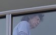 Nemocný Mick Jagger v teplákách na balkoně. 