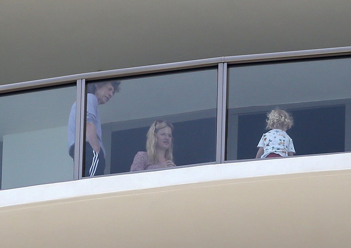 Nemocný Mick Jagger v teplákách na balkoně se svou dcerou. 
