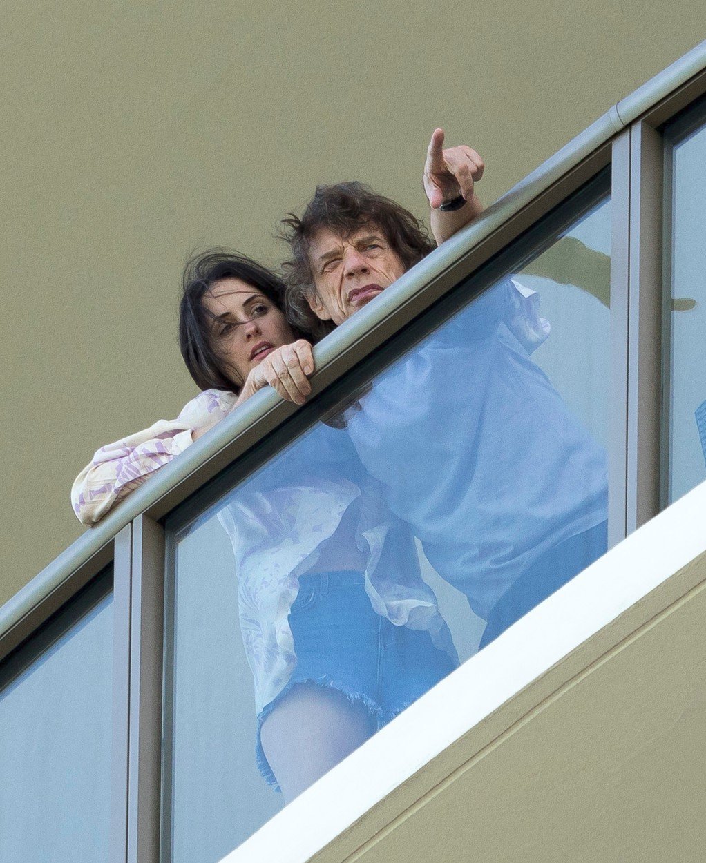 Nemocný Mick Jagger v teplákách na balkoně se svou manželkou Melanií Hamrick.