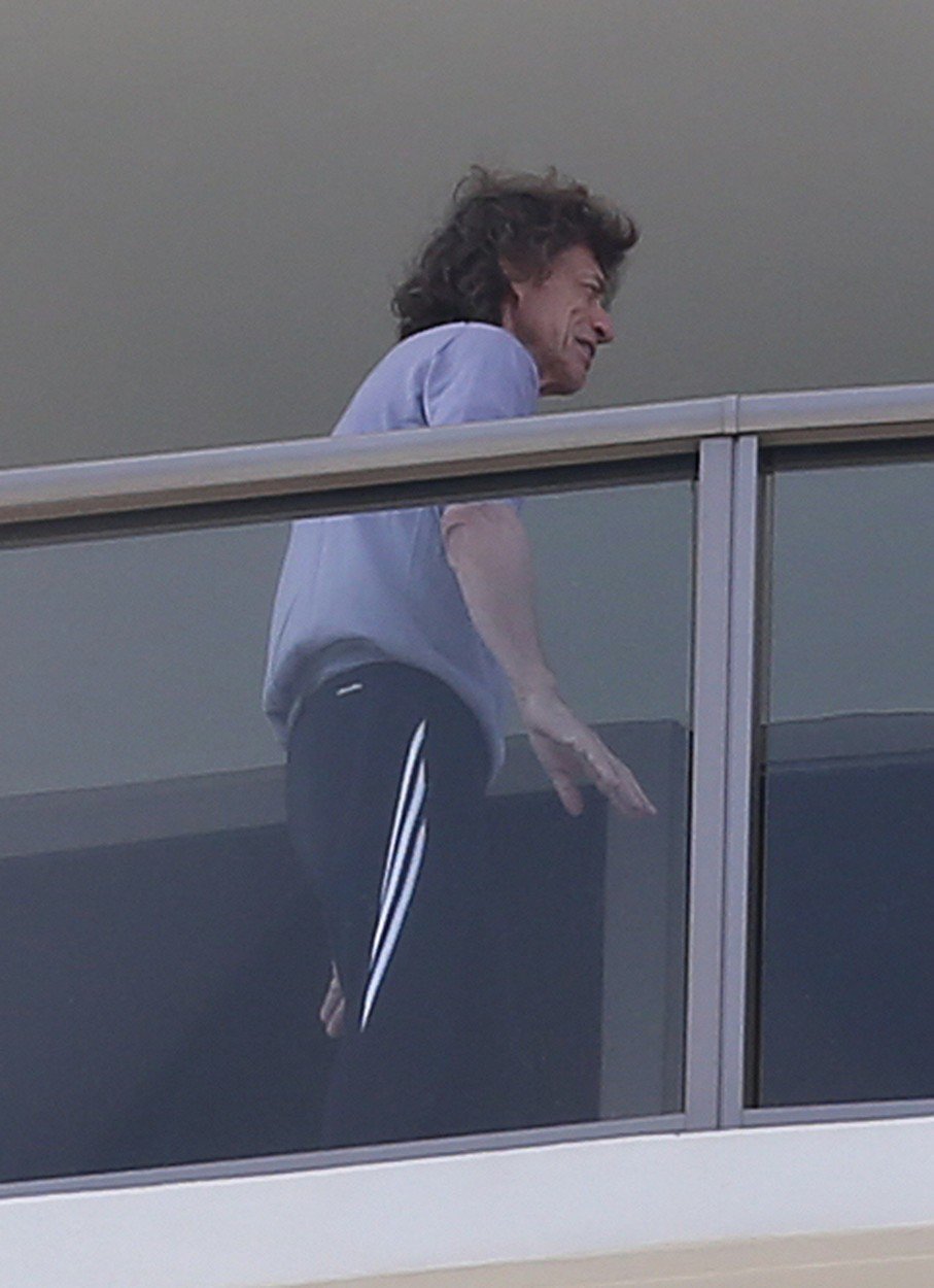 Nemocný Mick Jagger v teplákách na balkoně.